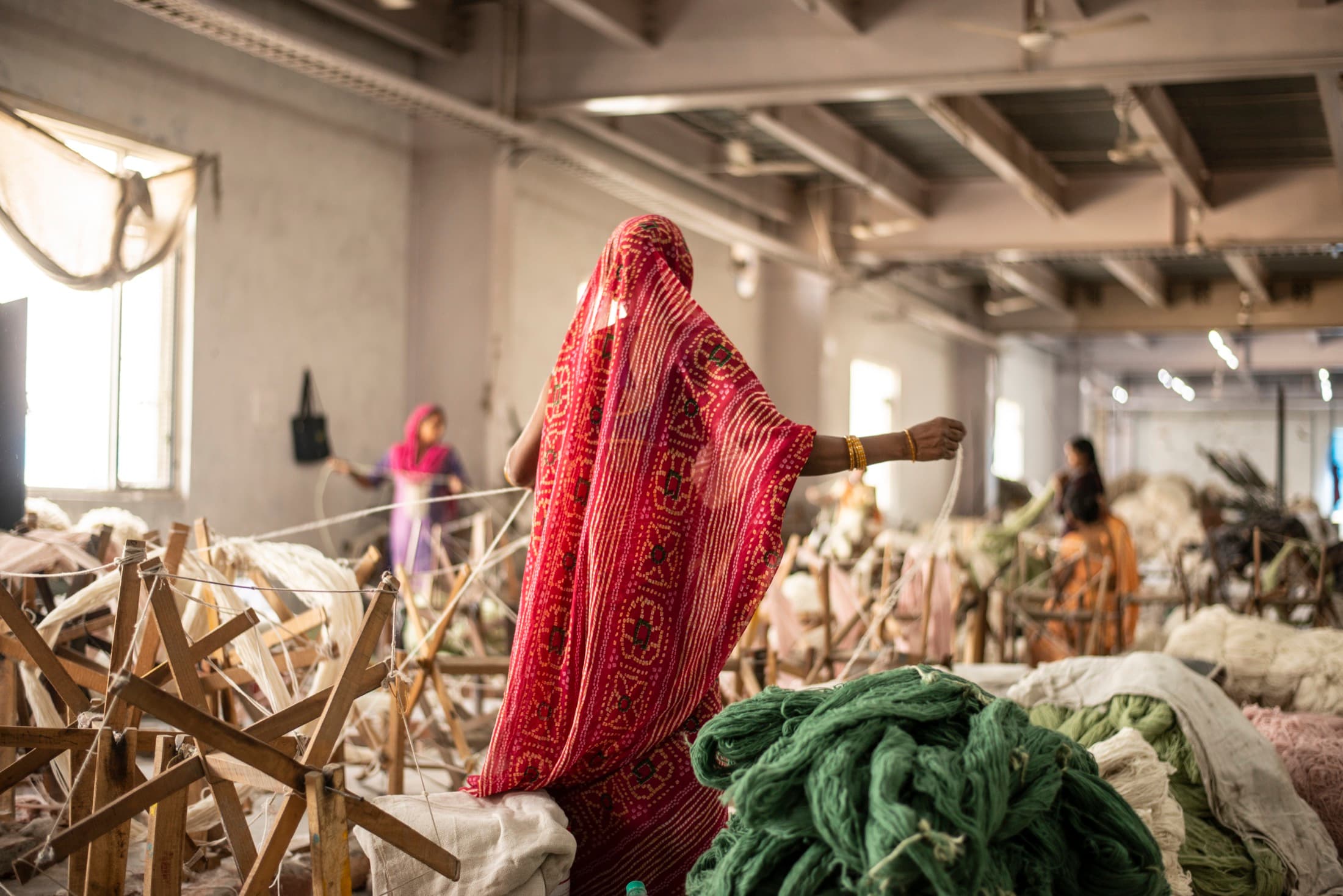 Textile artisans working with yarn inside a studio